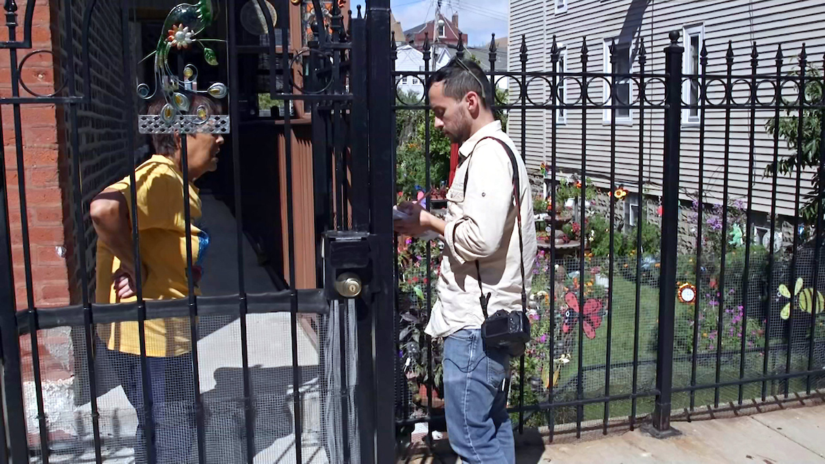 A reporter conducts interviews on the street.